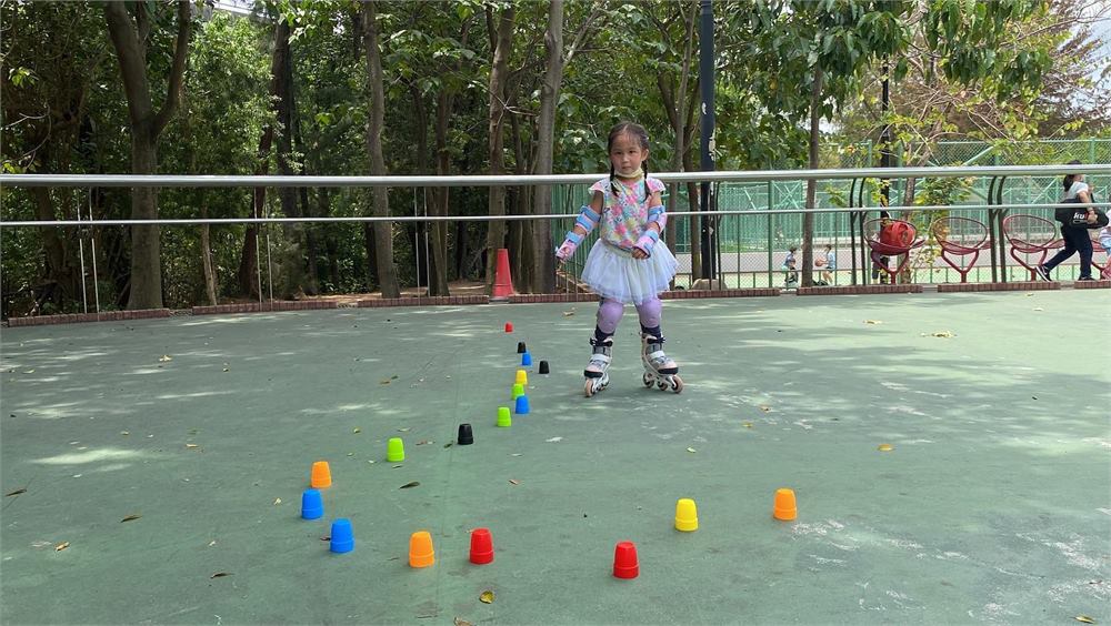 兒童和青少年在戶外場地練習兒童滾軸溜冰班動作